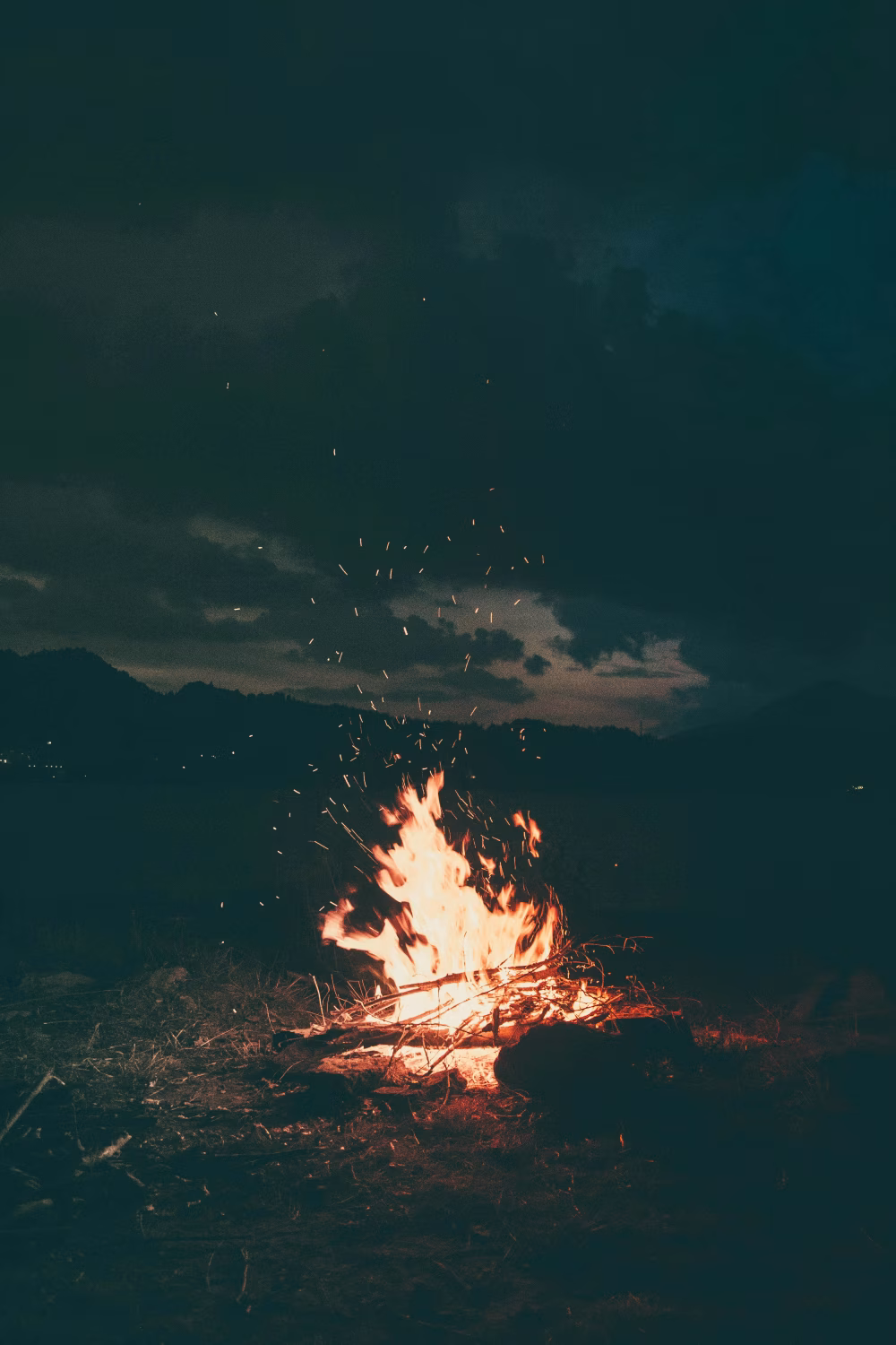 Burning Campfire Under a Dark Night Sky with Glowing Embers