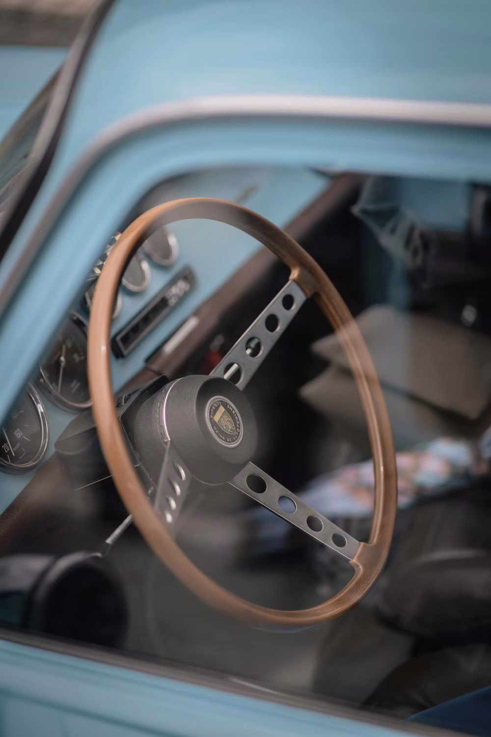 Close-Up of Classic Car Interior With Wooden Steering Wheel and Dashboard Gauges