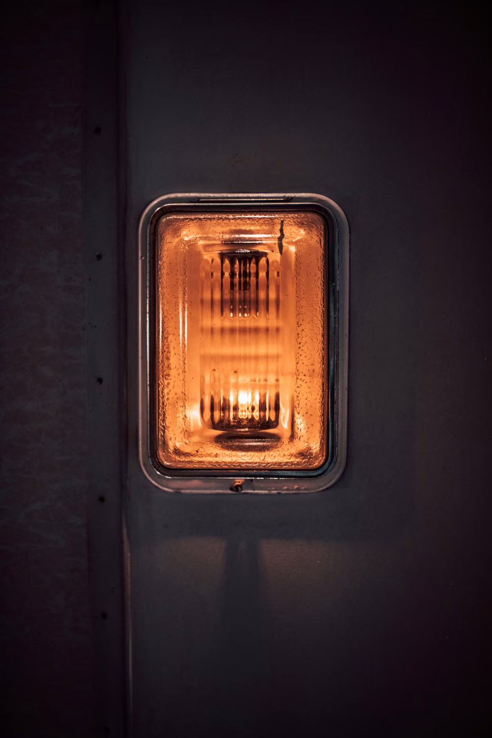 Closeup of an Amber Light Fixture on a Metallic Surface