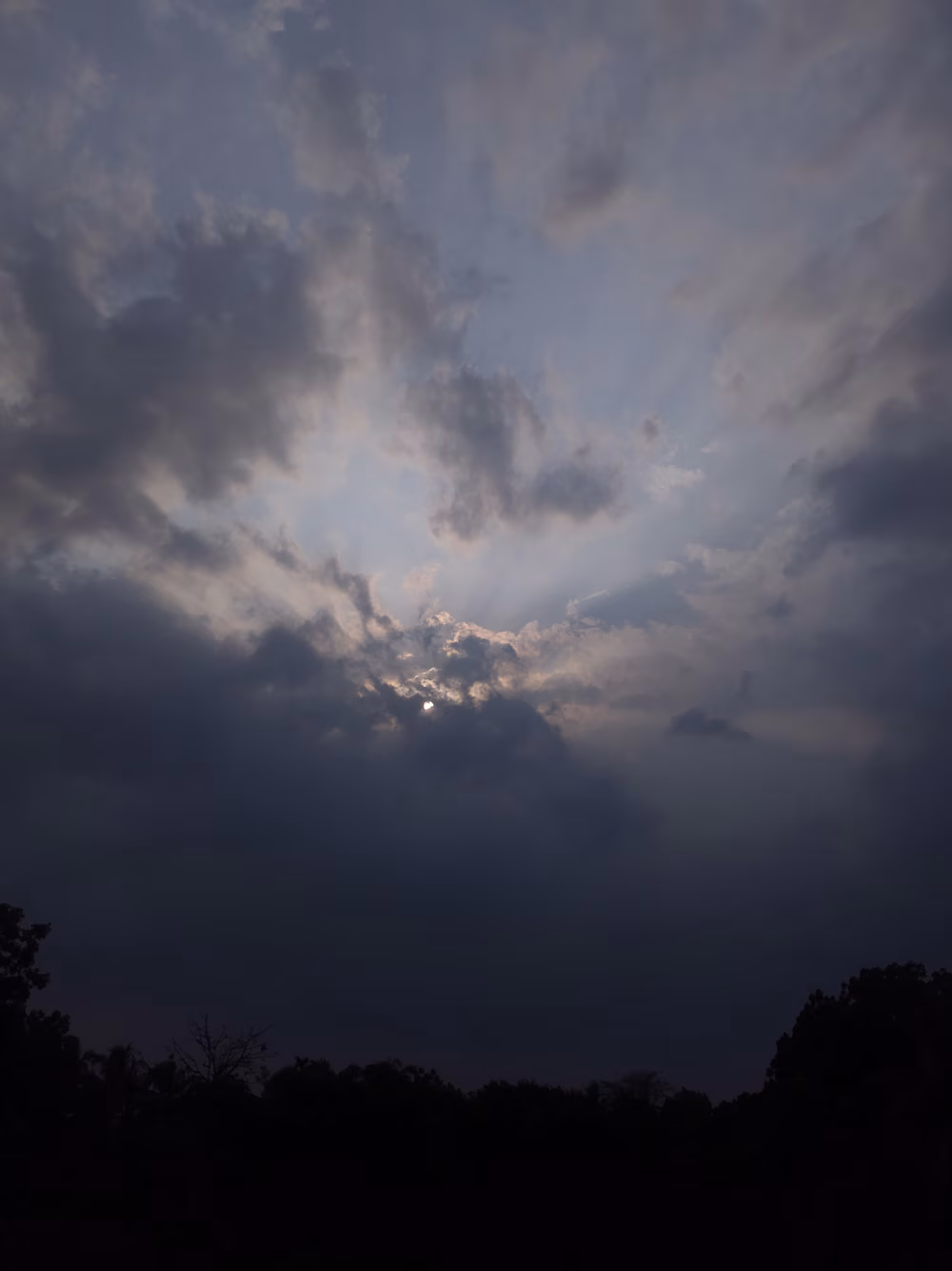 Dramatic Evening Sky with Sun Rays Piercing Through Clouds