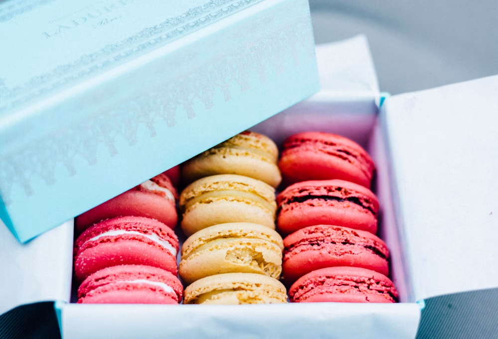 Elegant Box of Colorful French Macarons in Pastel Packaging on Display