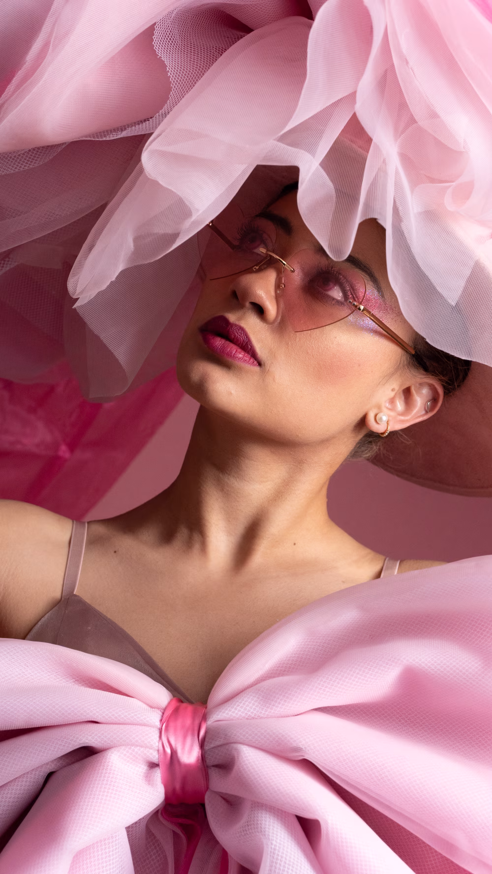 Elegant Woman Wearing Pink with Stylish Sunglasses and Artistic Fashion Details