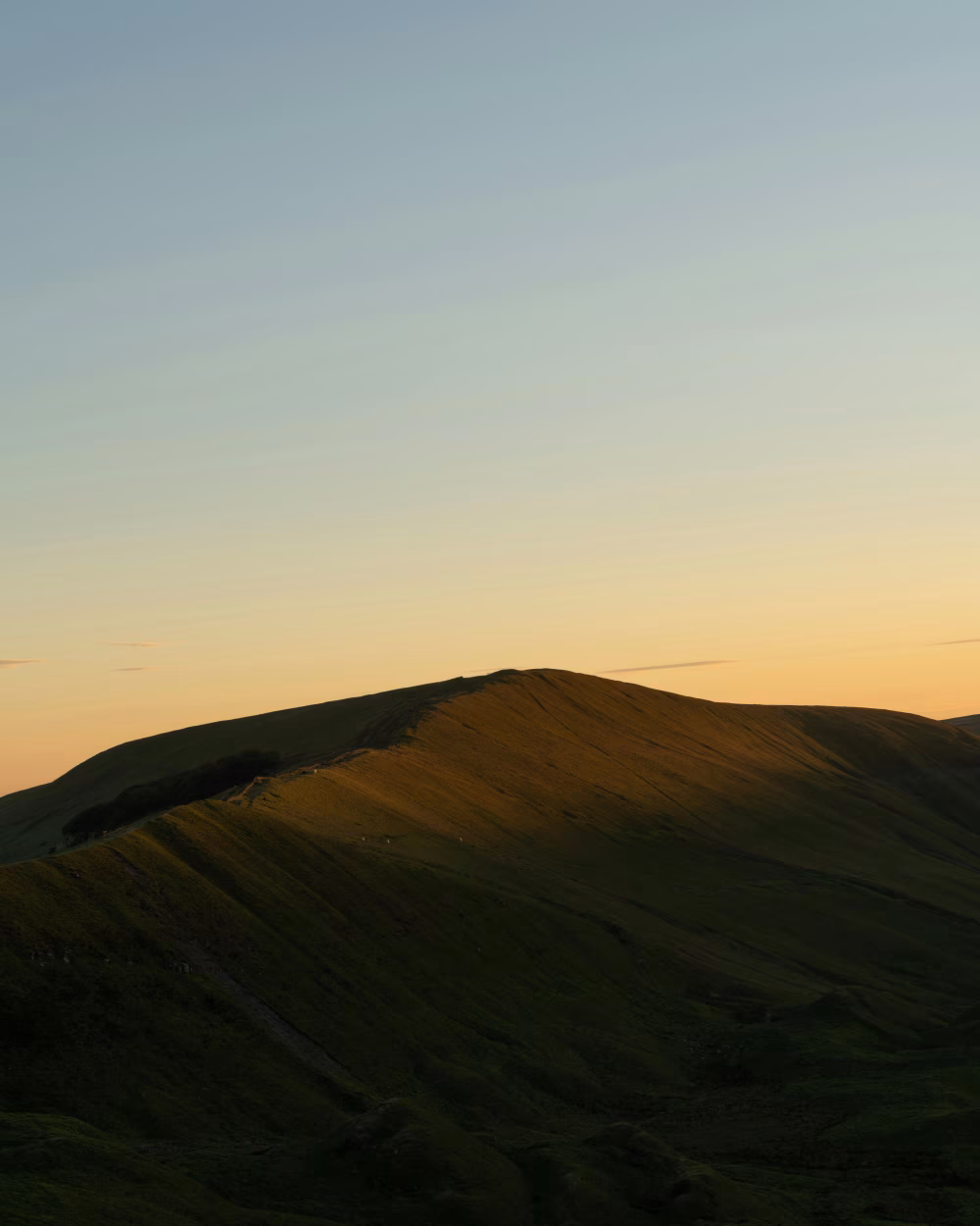 Golden Hour Over Rolling Hills With Dramatic Shadows and Serene Atmosphere