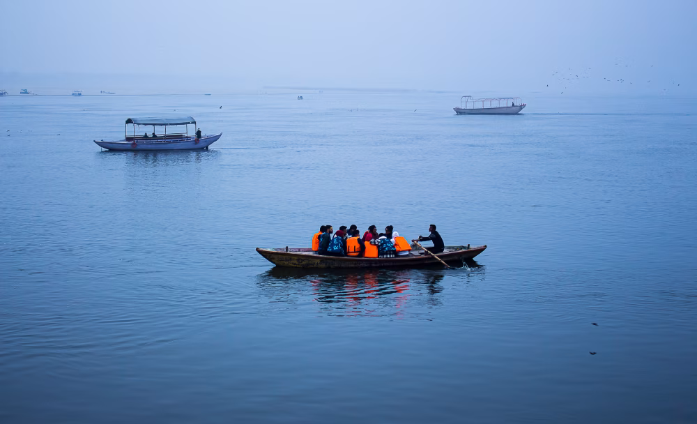 Group of People Boating on Calm River Waters Under Clear Sky