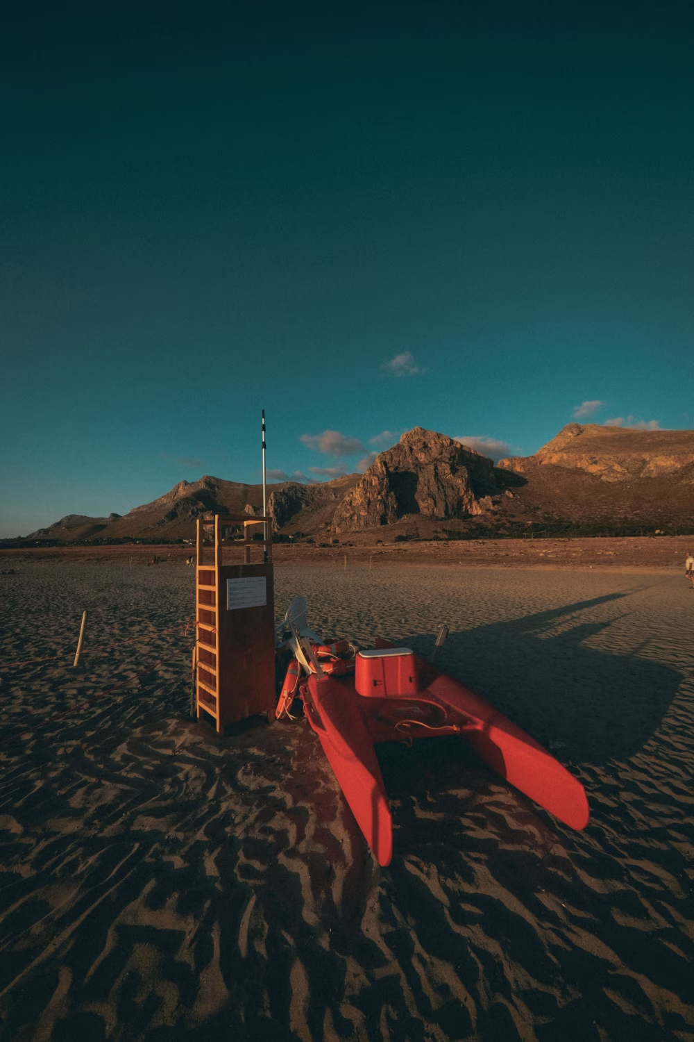 Lifeguard Stand and Rescue Boat on a Tranquil Sandy Beach at Sunset