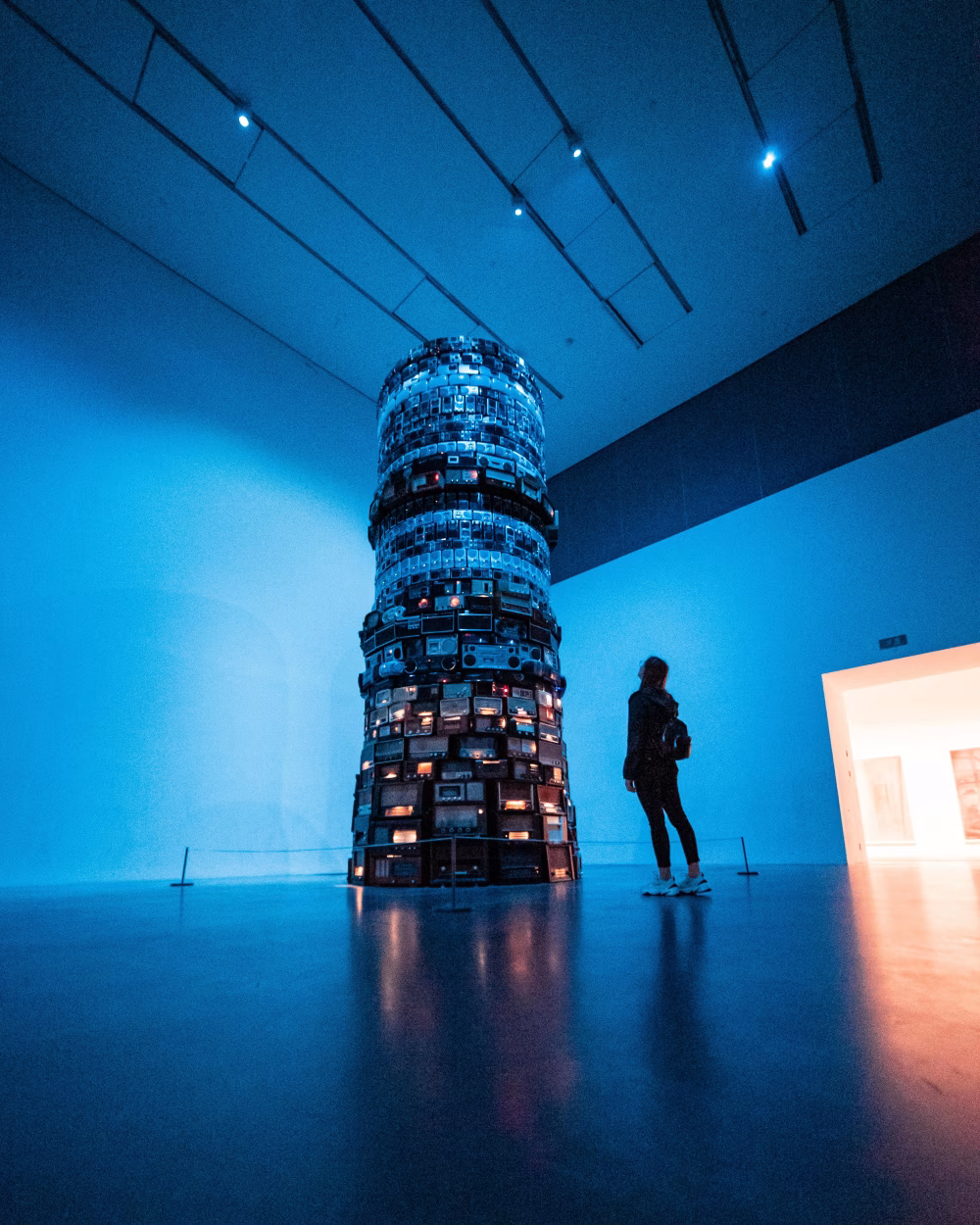 Modern Art Exhibition Displaying Tower of Vintage Radios in Blue Lighting