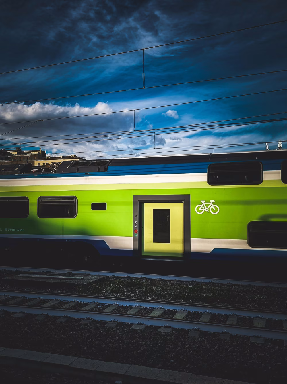 Modern Green Train With Bicycle Symbol Under Dramatic Cloudy Sky