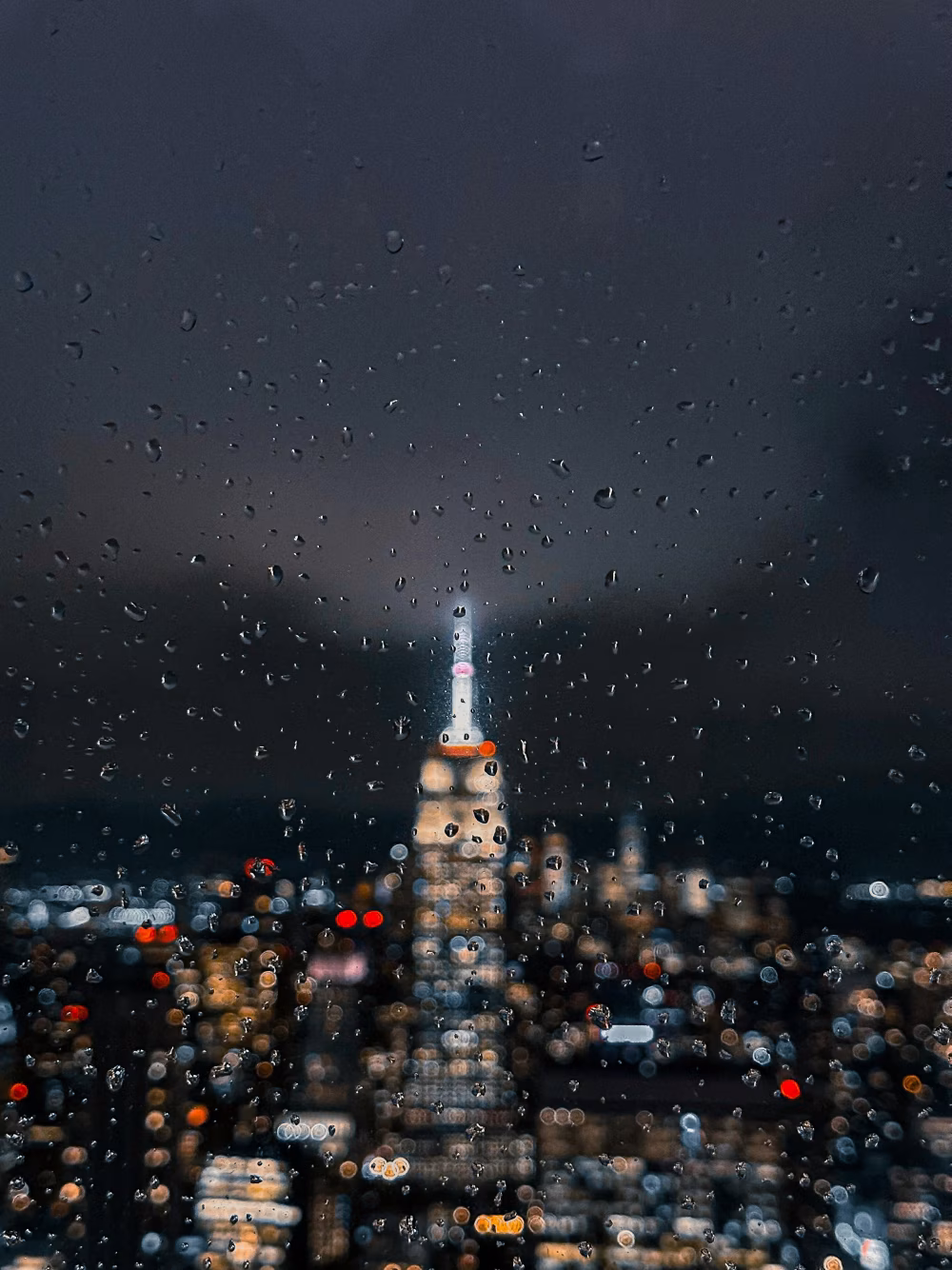 Raindrops on Glass with City Lights and Building at Night