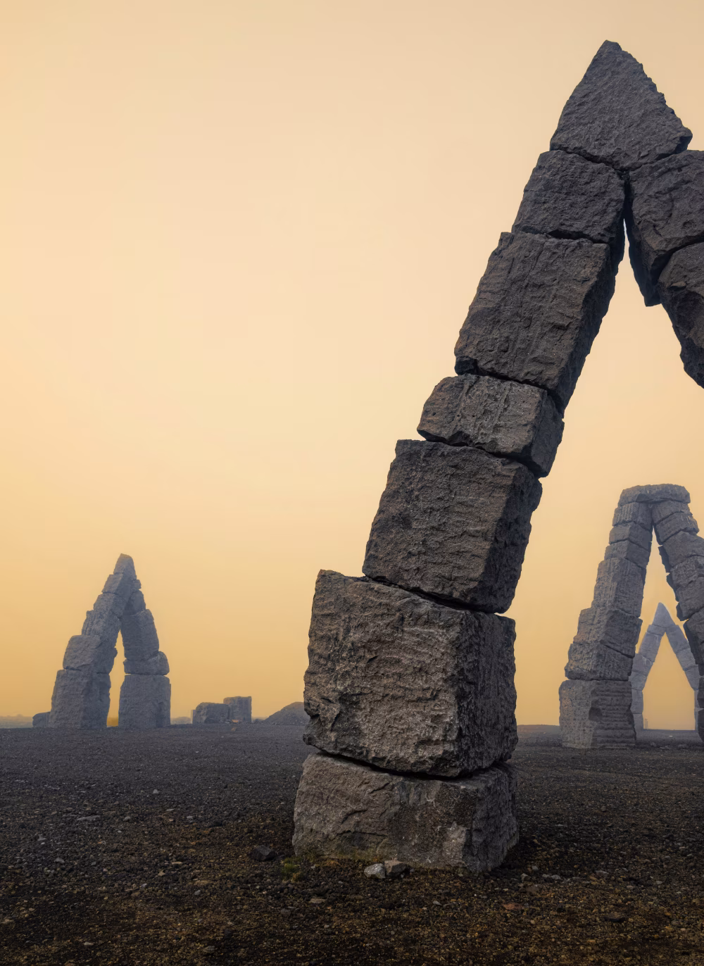 Stone Arch Structures Against a Foggy Yellow Sunset Sky