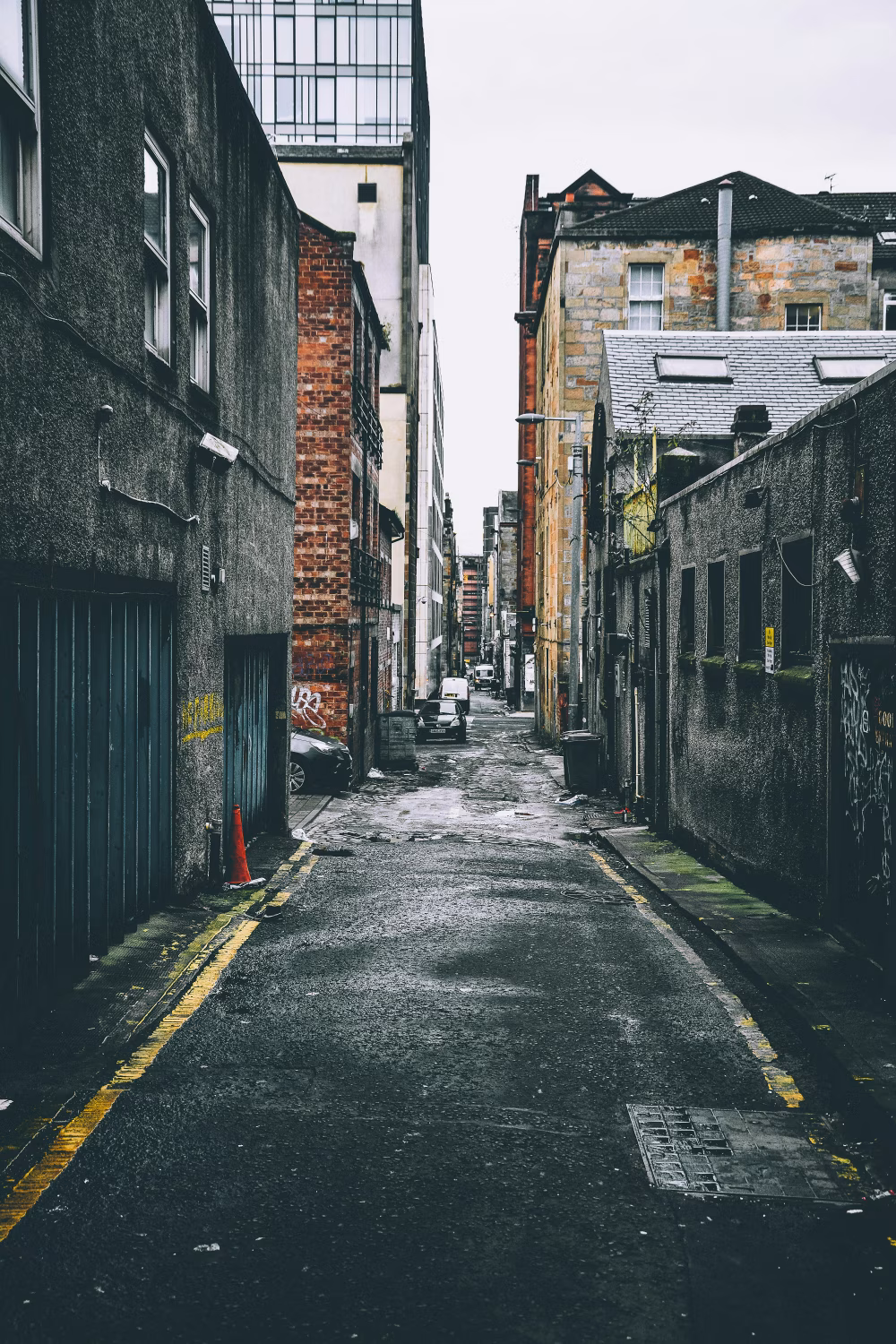 Urban Alleyway with Brick Buildings and Graffiti in Moody Lighting