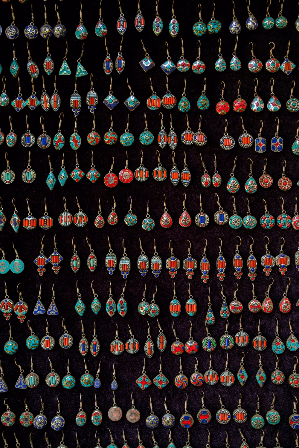 Vibrant Multicolored Artistic Earrings Displayed in Rows on Black Background