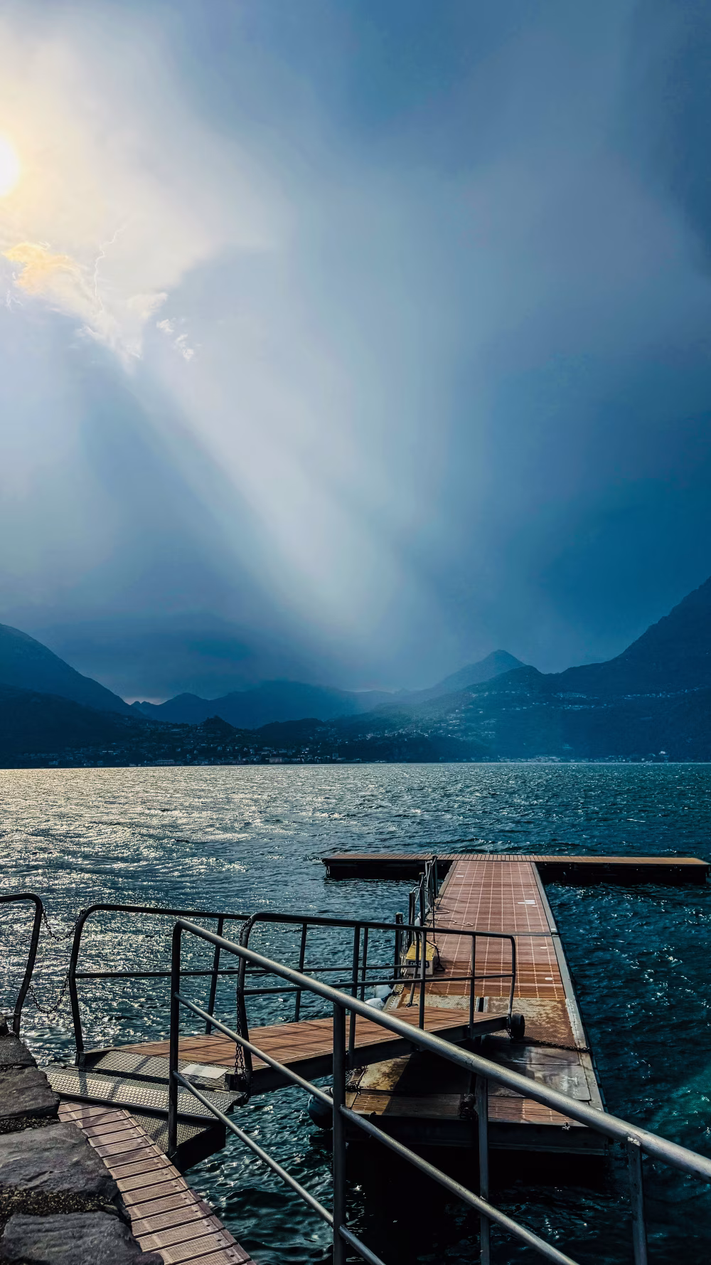 Wooden Pier Extending Over a Lake Under a Scenic Stormy Sky