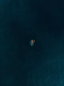Aerial View of a Person Relaxing on a Raft in Calm Water