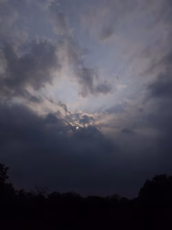Dramatic Evening Sky with Sun Rays Piercing Through Clouds
