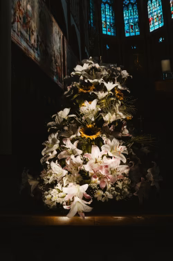 Elegant Display of Lilies and Flowers Illuminated by Sunlight Inside a Church
