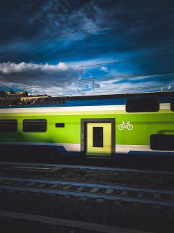 Modern Green Train With Bicycle Symbol Under Dramatic Cloudy Sky