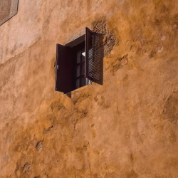 Old Weathered Wall with Open Window and Wooden Shutters
