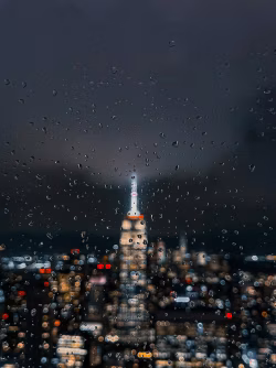 Raindrops on Glass with City Lights and Building at Night