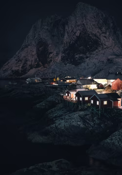 Scenic Nordic Village at Night Amidst Snowy Mountains and Ocean