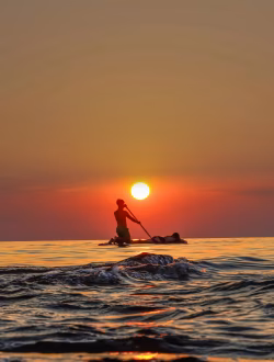 Silhouette of Paddler on Calm Ocean at Sunset