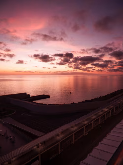 Sunset Over Calm Ocean and Pier: Serene Waterfront Landscape at Dusk