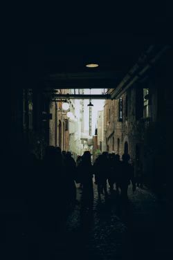 Urban Alleyway with Silhouetted Crowd and Dim Ambient Lighting