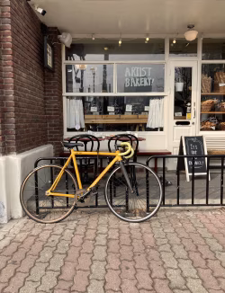Yellow Bicycle Against Modern Street Bakery Exterior with Brick Details