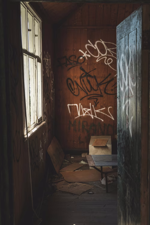 Abandoned Room with Graffiti Walls and Scattered Debris