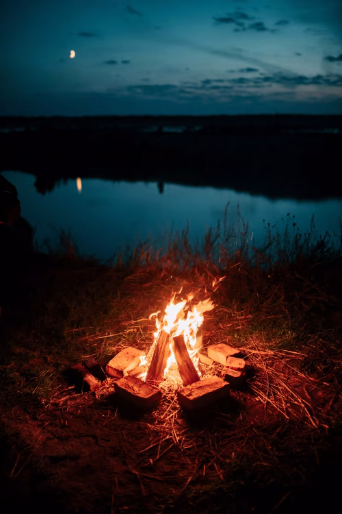 Campfire by a Serene Lake Under the Moonlit Evening Sky