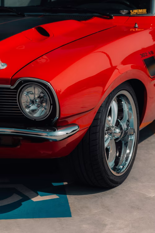Close-Up of Red Vintage Car with Chrome Detailing and Headlight