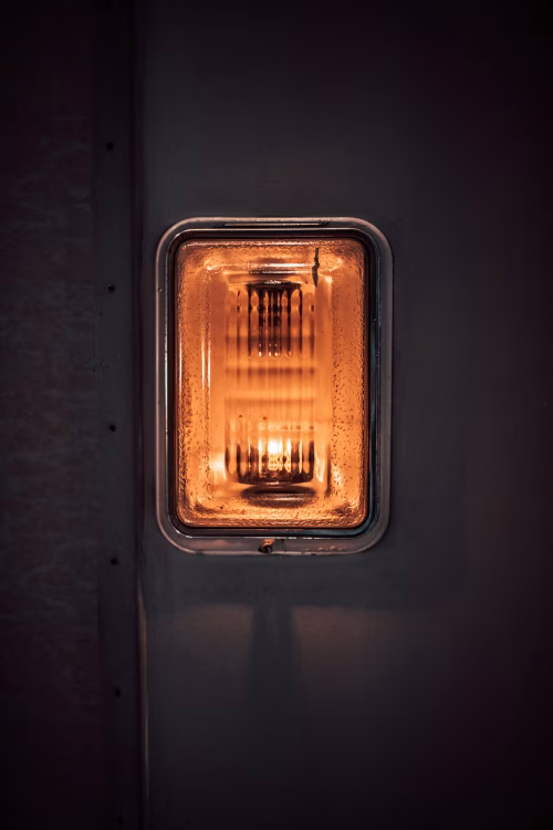 Closeup of an Amber Light Fixture on a Metallic Surface