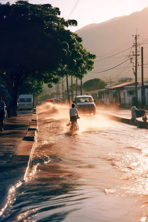 Cyclist Navigating a Flooded Sunlit Road During Golden Hour