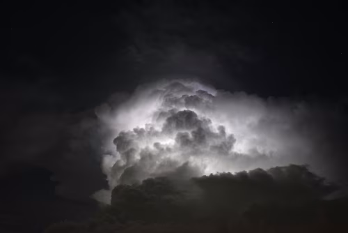Dramatic Thundercloud Illuminated by Lightning in a Dark and Moody Night Sky