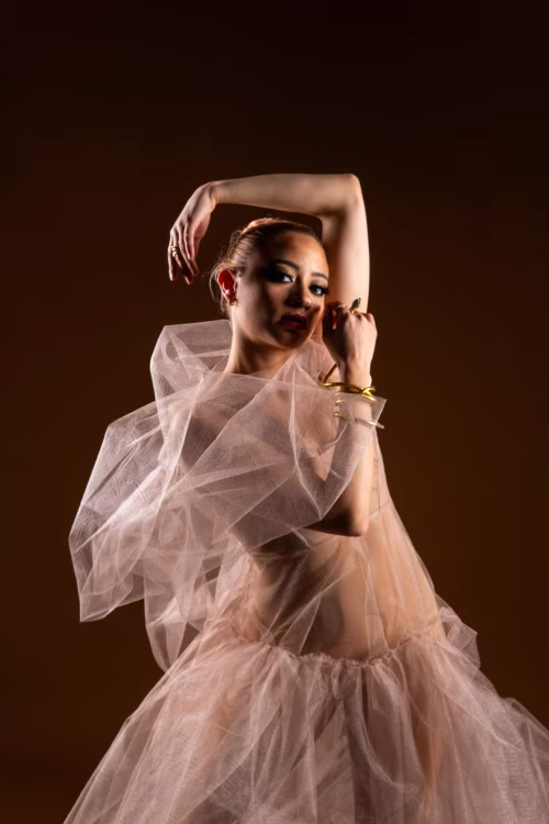 Elegant Female Model Posing in a Delicate Flowing Fabric Ensemble