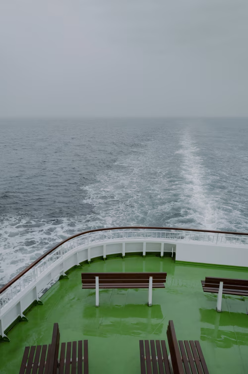 Empty Deck of a Ship Overlooking the Vast Open Sea on a Cloudy Day
