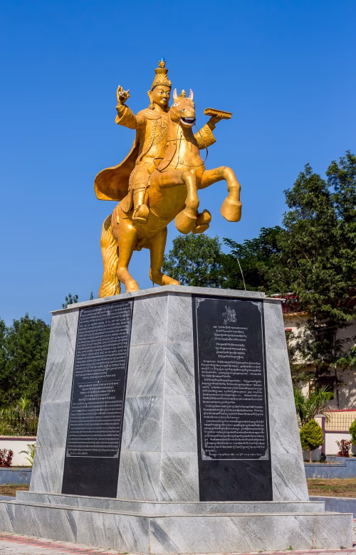 Golden Horse Statue On Marble Pedestal Monument Under Clear Blue Sky With Trees In Background