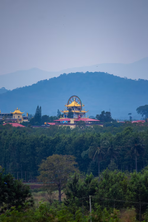 Golden Temple Complex Among Green Hills Under Soft Blue Sky at Sunrise