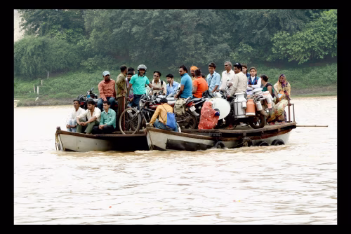 Group Of People On A Floating Ferry With Bicycles And Musical Drums On A River