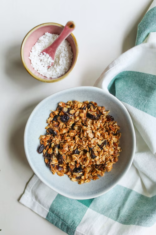 Healthy Homemade Granola Breakfast with Coconut Topping on a Light Table Surface