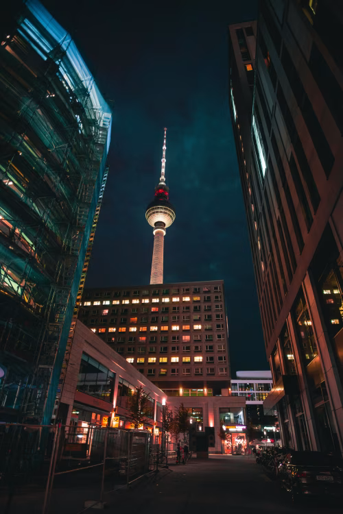 Illuminated City Street at Night Featuring Iconic Television Tower