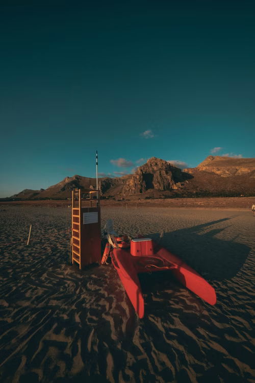 Lifeguard Stand and Rescue Boat on a Tranquil Sandy Beach at Sunset