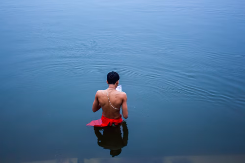 Man Performing Religious Ritual in a Calm River Setting