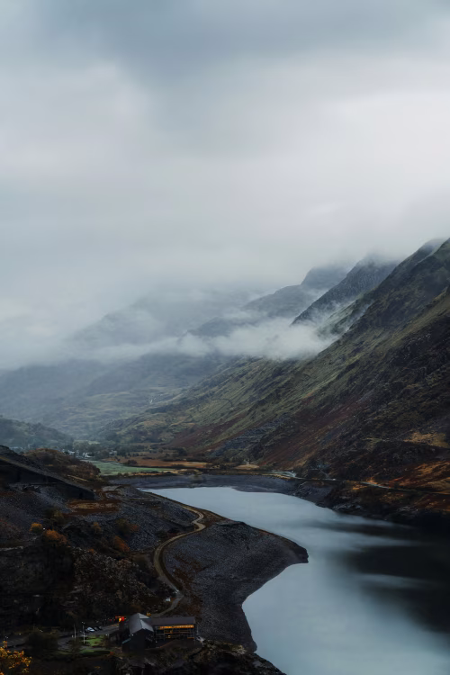 Misty Valley Landscape with Mountain Lake and Cloudy Atmosphere