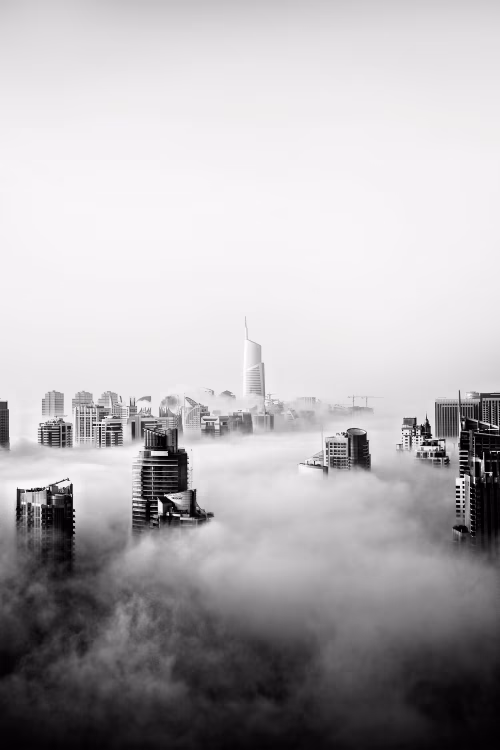 Modern City Skyline Rising Above Clouds in Black and White View