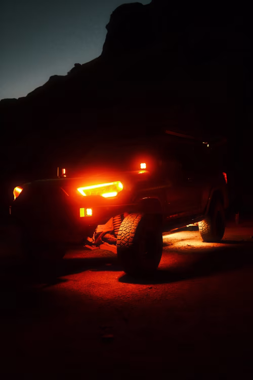 Offroad Vehicle Illuminated With Red Lights at Dusk in a Scenic Landscape