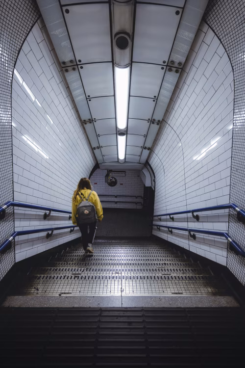 Person in Yellow Hoodie Walking Down Subway Stairs