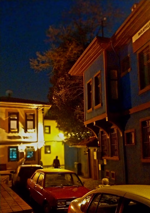 Quiet Street at Night with Warm Street Lighting and Parked Cars