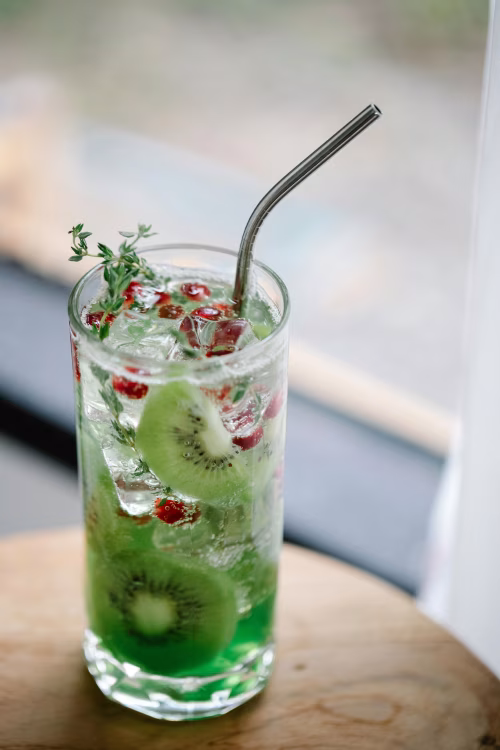 Refreshing Kiwi Cocktail with Berries and Mint in a Tall Glass