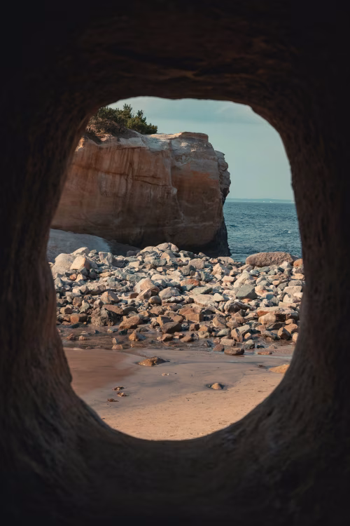 Rocky Seaside Cave With View of Ocean and Cliffs