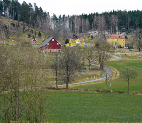 Rural Farm Landscape with Colorful Houses and Rolling Green Fields